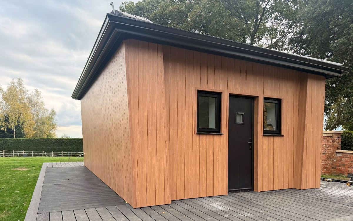 The completed timber-clad garden building with a dark roof